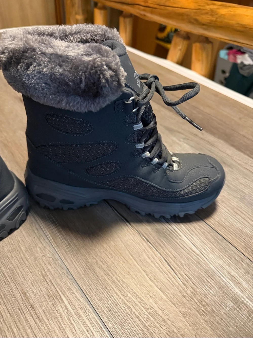 Skechers D'Lites Bomb Cyclone winter boots in a charcoal color, featuring a faux